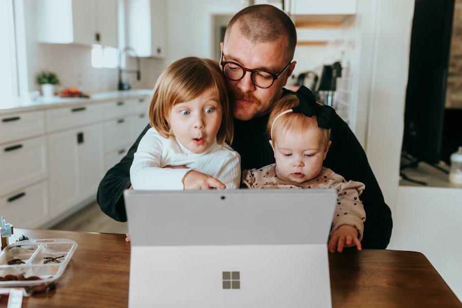 Father and two young daughters looking at a tablet together