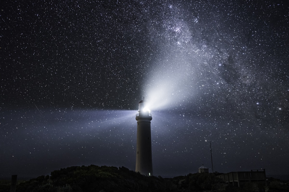 Lighthouse beam sweeping under the Milky Way
